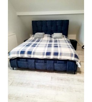 Designerskie łóżko tapicerowane z wysokim zagłówkiem